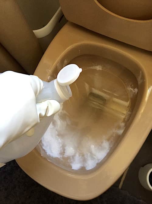 Verser le vinaigre blanc par dessus le bicarbonate dans la cuvette des WC