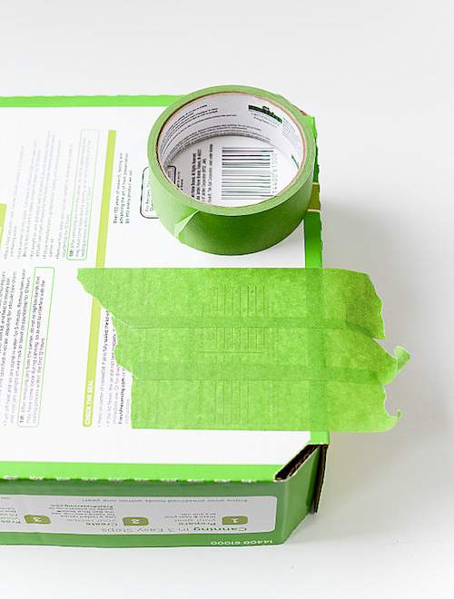 Poser 3 bandes de ruban adhésif sur la boîte en carton