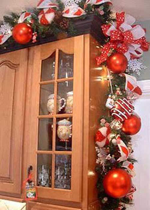 Guirlandes boules rouge et ruban blanc accrochés au placard de la cuisine