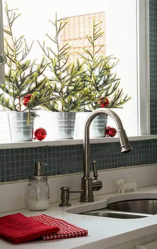 3 petits arbres de Noël sur le rebord de fenêtre de la cuisine