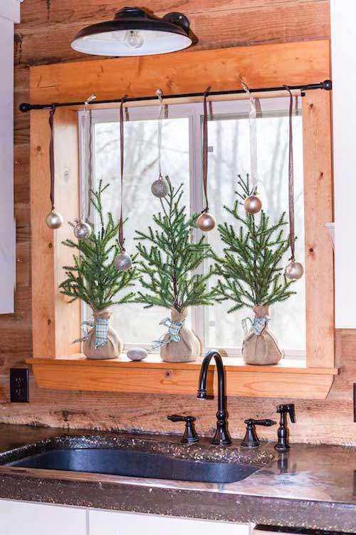 3 petits arbres de Noël devant la fenêtre de la cuisine