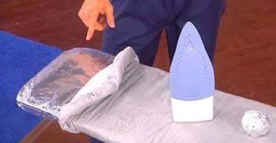 table à repasser avec du papier alu pour économiser de l'électricité