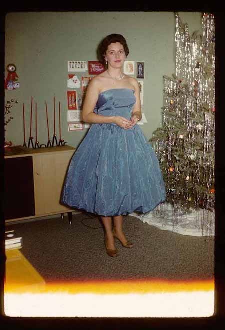 femme robe bleue devant le sapin de noel