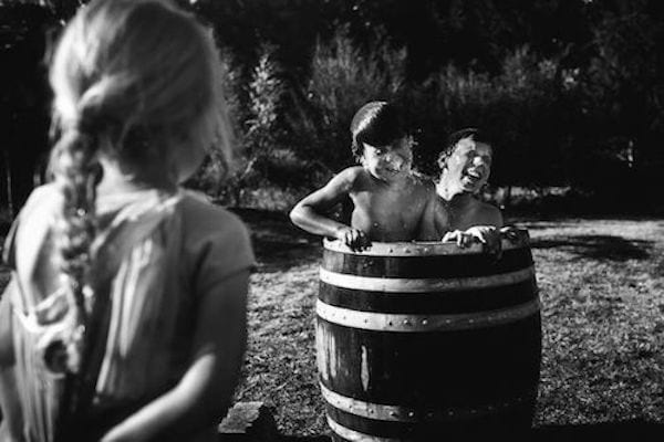 photo en noir et blanc d'enfants jouant dans des bacs d'eau