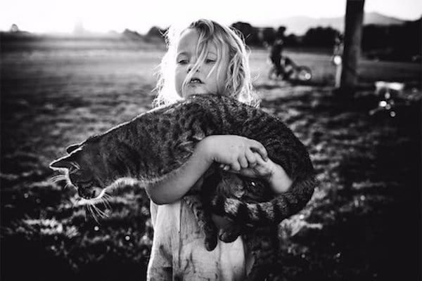 Photo en noir et blanc de nkki boon d'une petite fille qui porte un chat