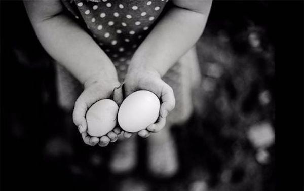 photo de Nikki Boon en noir et blanc d'une petite fille portant des oeufs