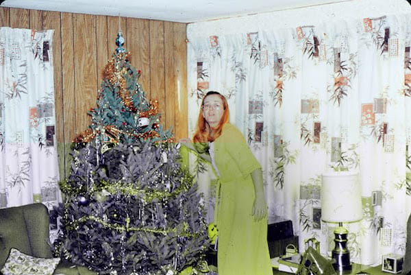 femme robe jaune devant sapin de noel