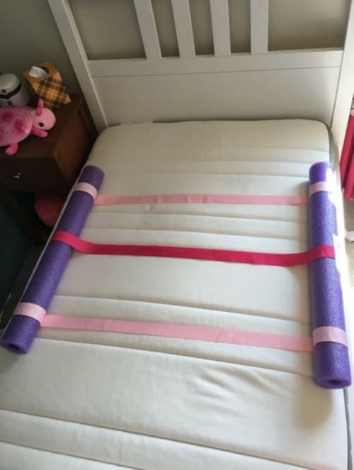des nouilles de piscine pour sécuriser un lit