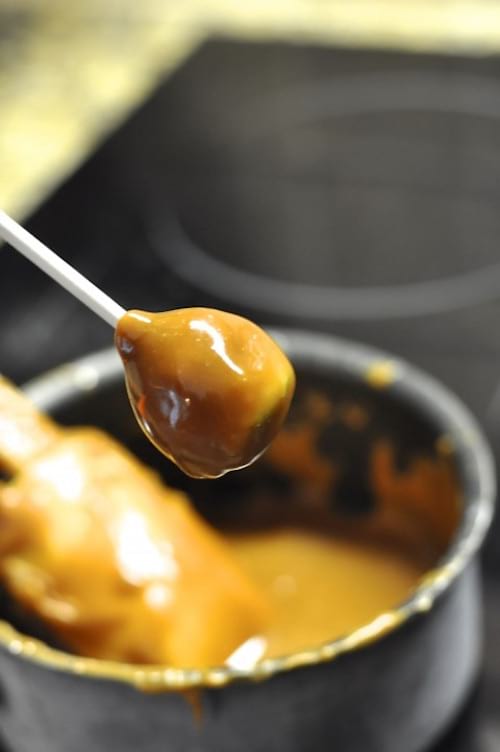 les sucettes de pommes sont trempées dans le caramel