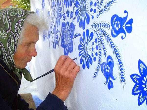 une grand-mère tchèque peint des fleurs sur les murs des maisons