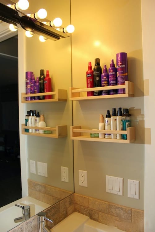 Shelves installed in the bathroom are used to store hair and makeup products