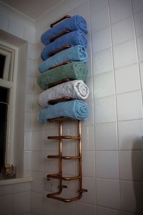 a shelf for towels made with copper pipes