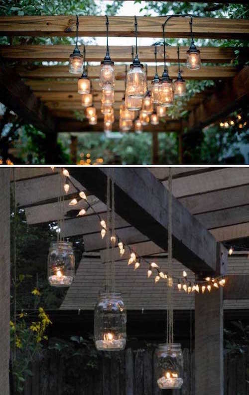 des bocaux illuminés sont suspendus à une pergola en bois