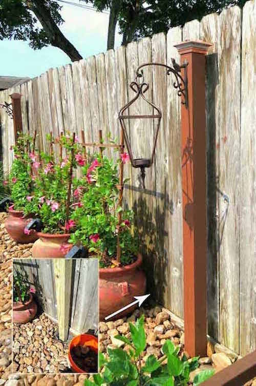 un poteau en bois orné d'une grande lanterne solaire dans un jardin