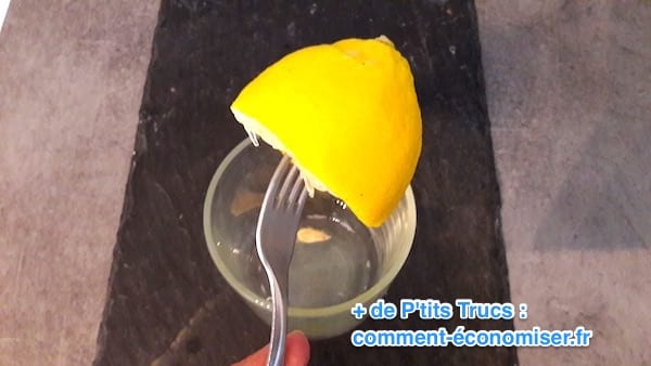 A lemon pricked on a fork to squeeze it more easily