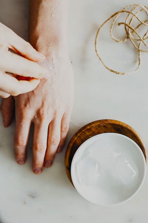 Une femme qui utilise des glaçons pour soigner un piqûre de moustique.