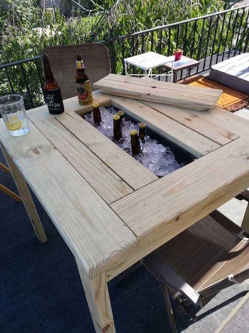 une table pour déjeuner sur la terrasse avec un espace intégré pour refroidir les boissons