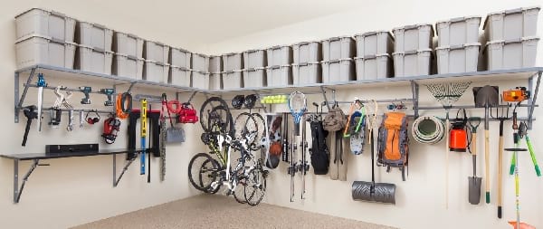garage bien rangé avec des boites en plastique, des outils ou des vélos suspendus