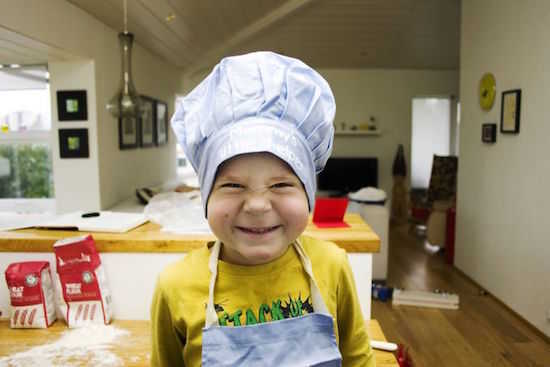 Petit garçon qui fait la cuisine avec ses parents
