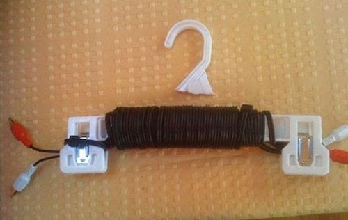 Recycler vos cintres en plastique pour ranger vos câbles électriques.