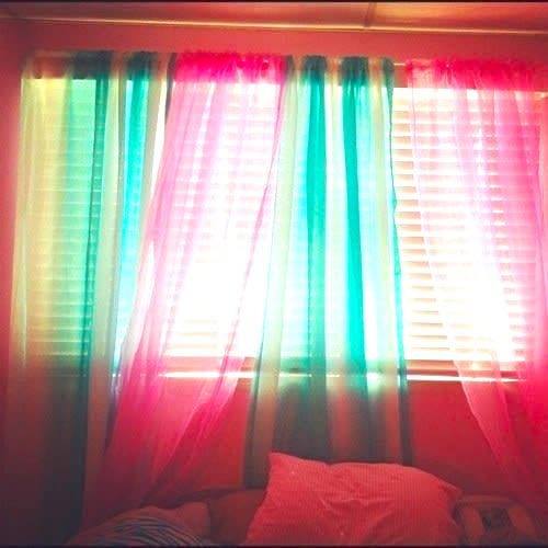 Déco DIY pour la maison : assortissez des voilages de différentes couleurs pour relooker une fenêtre.