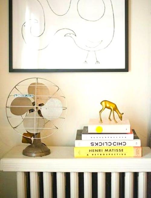 Parfois, les meilleurs rangements sous juste sous votre nez ! Empilez les livres sur un radiateur hors-service pour gagner de la place dans un petit appartement.