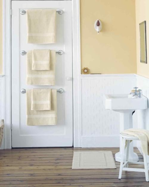 Des portes-serviettes installés derrière la porte de la salle de bains pour gagner de la place