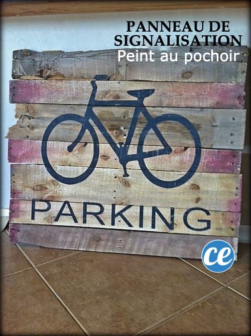 Un panneau de signalisation pour garer les vélos fait avec des planches de palettes