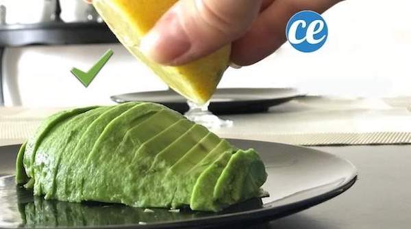 Du jus de citron pressé sur un avocat coupé en tranches pour éviter qu'il ne noircisse