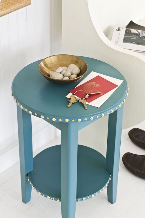 Plusieurs punaises sont enfoncées dans une mini table pour la décorer