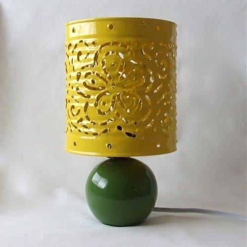 Une boîte de conserve décorée et découpée en jaune pour former une lampe 