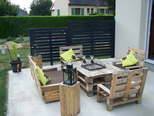Lieu en extérieur avec des chaises et une table pour des inviter faits avec plusieurs palettes en bois 