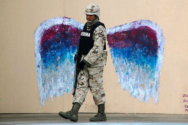 Soldat devant des ailes taguées sur le mur