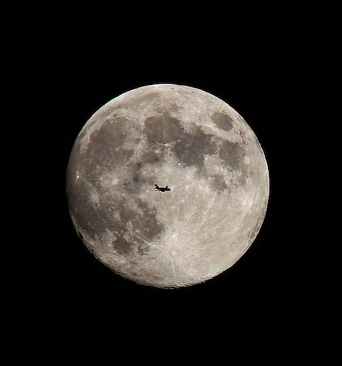 Avion de voyage devant la lune en arrière plan