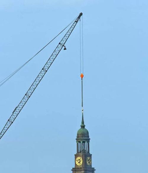 Grue au dessus d'une tour avec une grande horloge