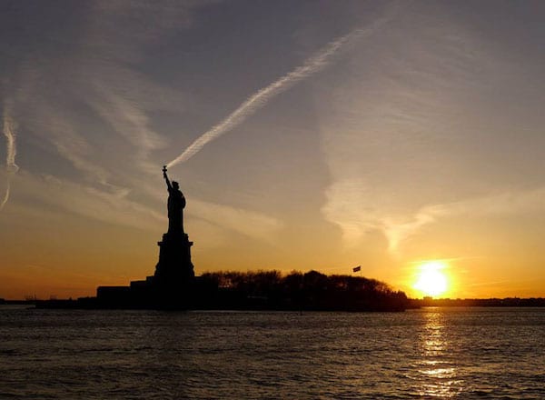 Statue de la liberté avec de la fumée d'avion au dessus