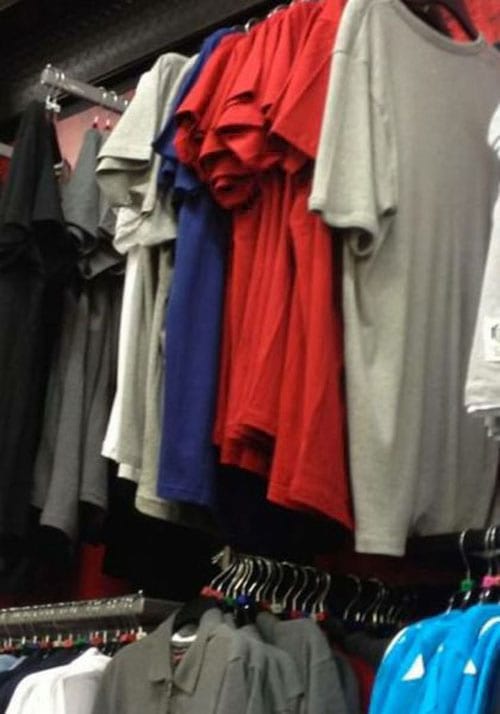 Plusieurs vêtements de différentes couleurs accrochés grâce à des cintres