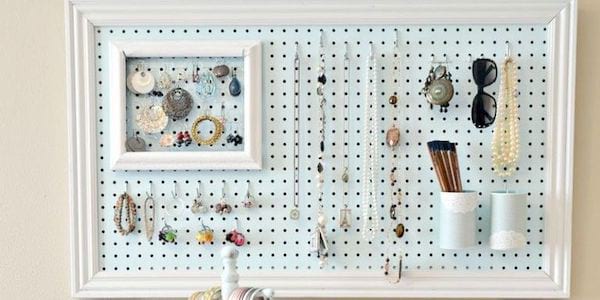 Plusieurs bijoux accrochés sur un tableau à piquets bleu et blanc 