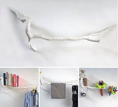 Branche d'arbre repeint en blanc accrochée au mur pour faciliter le rangement