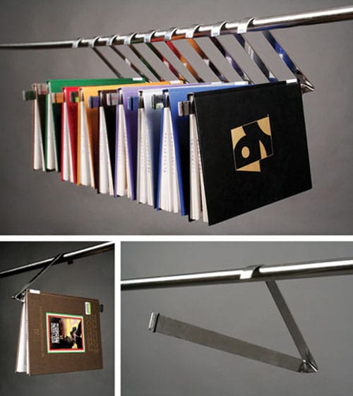Cintres suspendus à une barre grise servant de rangement pour livres 