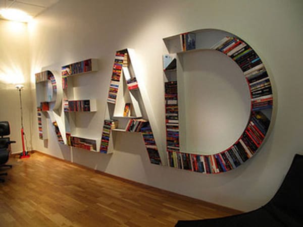 Décoration qui sert de rangement pour livres accrochée au mur et qui est écrit "READ"