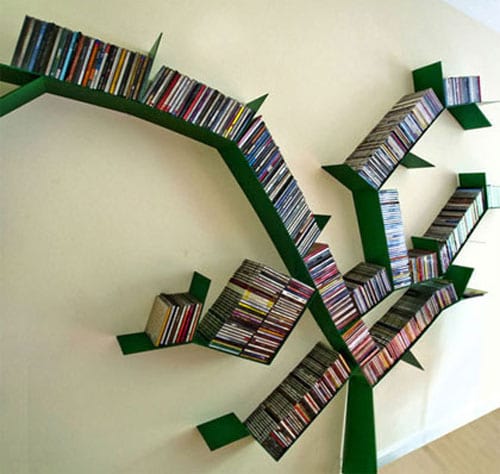 Décoration qui forme un arbre vert sans feuilles et qui sert de rangement pour livres au niveau du mur 