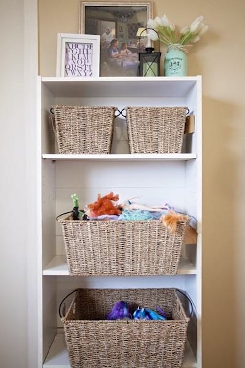 Des paniers de rangement en osier sur une étagère dans une chambre de fille