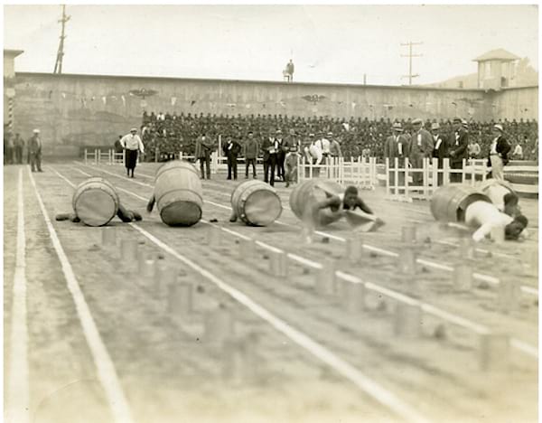 Plusieurs hommes faisant une course dans des tonneaux de bière