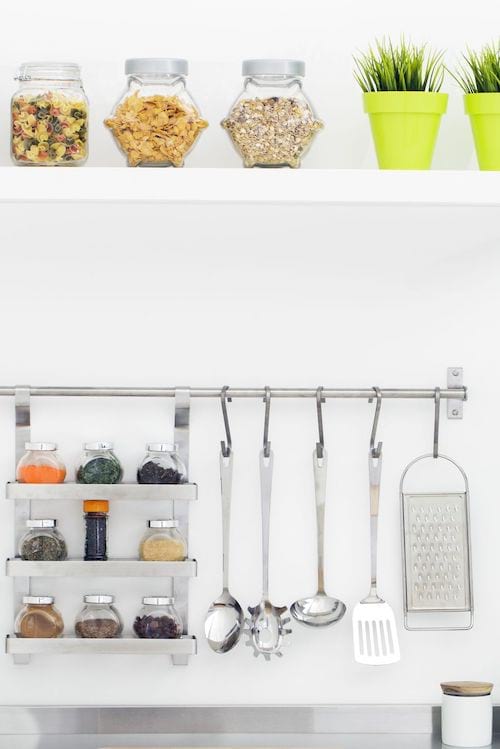 Ustensiles de cuisine suspendus au dessus de l'évier pour faciliter leurs portés