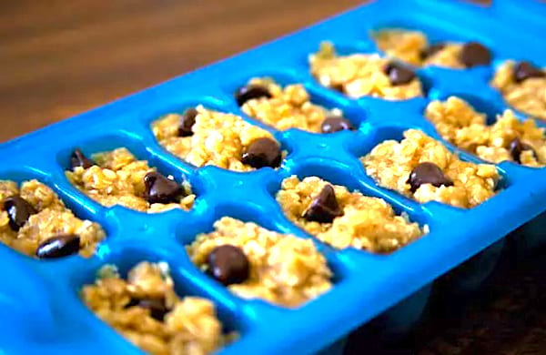 De la pâte à cookies dans un bac à glaçons bleu, pour faire des portions parfaites à réutiliser plus tard. 