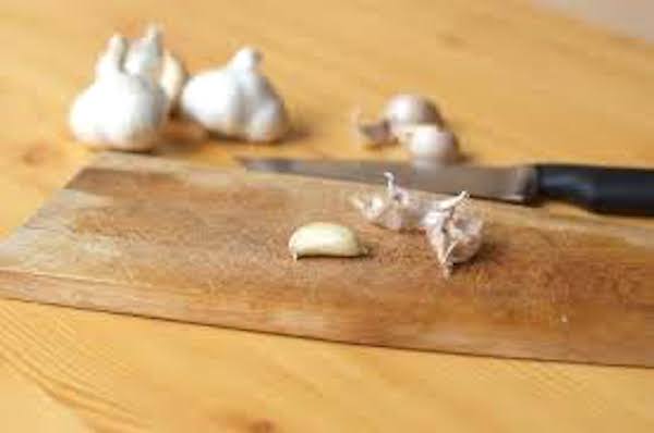 ail avec planche à découper en bois et couteau