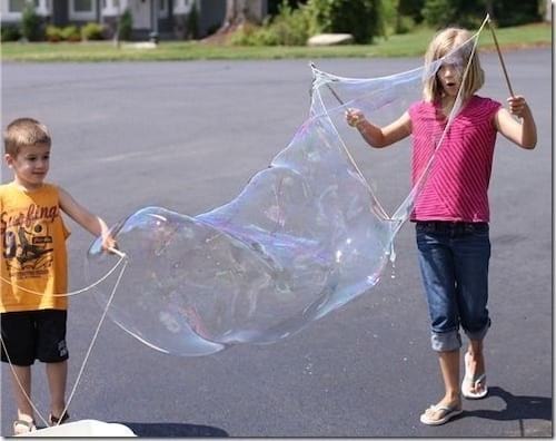 Des enfants jouent à faire des bulles de savon géantes
