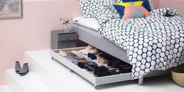 Tiroir sous un lit qui sert de rangement pour chaussures