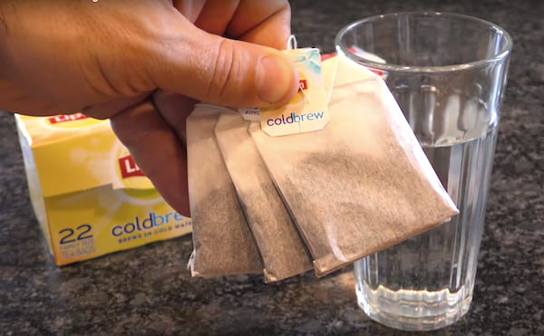 Des sachets de thé noir et un verre, tout ce dont vous avez besoin pour faire briller votre miroir !